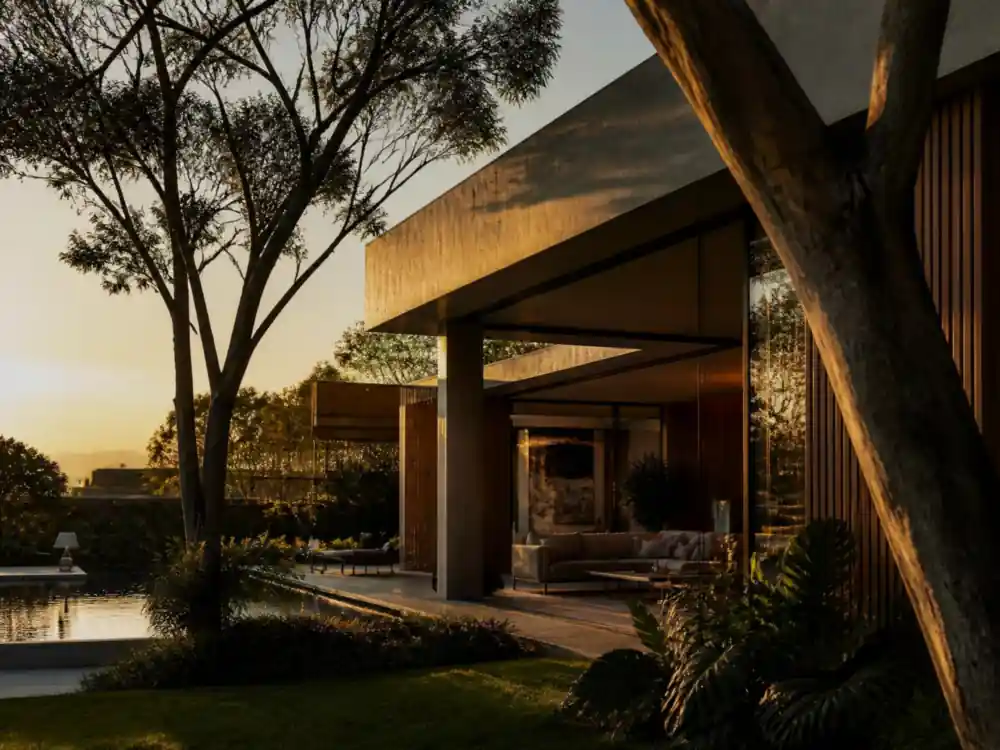 Residência contemporânea ao entardecer, com luz dourada natural refletindo em vidro e madeira.